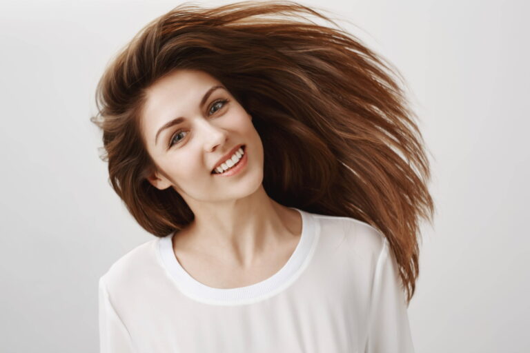 Beautiful young woman whip hair smiling haircare concept min (1)